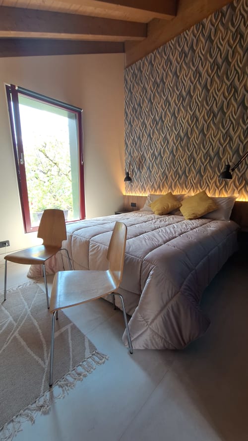 Modern bedroom at Locanda del Sasso in Crodo with mountain views, patterned wallpaper, and minimalist furnishings