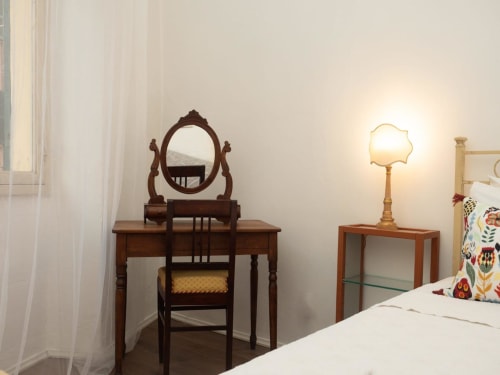 Camera elegante SleepWithMe Pisa con toilette in legno, specchio ornamentale, lampada vintage e biancheria bianca