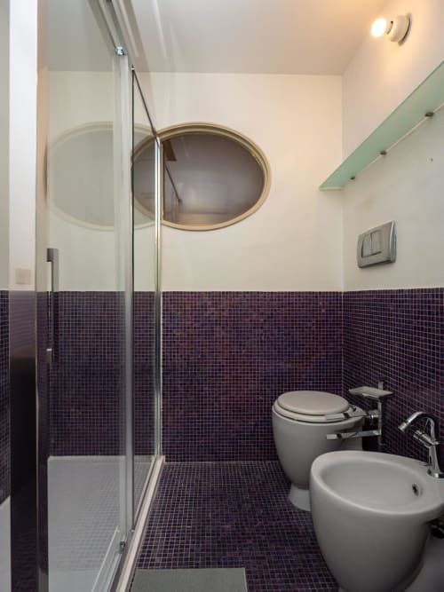 Bagno moderno del SleepWithMe Luxury B&B di Pisa con piastrelle mosaico viola, doccia in vetro e arredi contemporanei