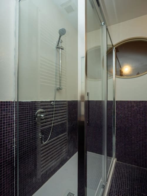 Doccia moderna con piastrelle a mosaico nero e box in vetro della lussuosa struttura SleepWithMe a Pisa