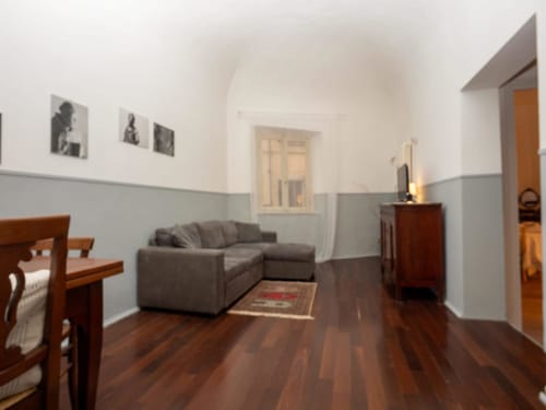 Soggiorno moderno presso il lussuoso B&B SleepWithMe a Pisa, Italia con divano componibile grigio e mobili in legno