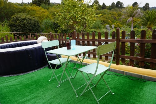 Terraza cottage en Casonas de Marengo con mesa y sillas verde menta sobre césped artificial, vista al jardín