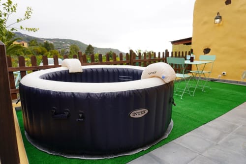 Black Intex hot tub on artificial grass terrace at Casonas de Marengo cottage in Icod de los Vinos, with mountain views and