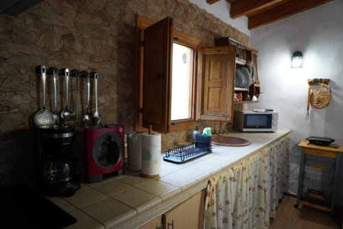 Cottage kitchen at Casonas de Marengo with cooking utensils, microwave, and white countertops