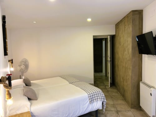Moderno dormitorio de apartamento en Mérida con cama queen, TV de pared y vistas a la ciudad