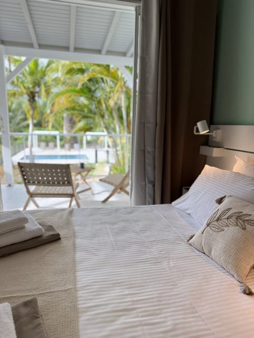 Bedroom with view of pool and palm trees at Domaine de la Glacière, Petit Bourg Guadeloupe