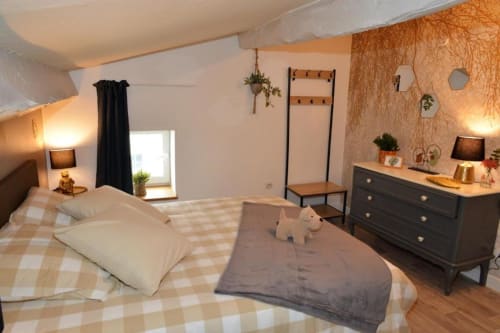 Chambre douillette à La Maison de Philomène B&B à Corme-Royal avec literie à carreaux, commode sombre et vue sur le jardin