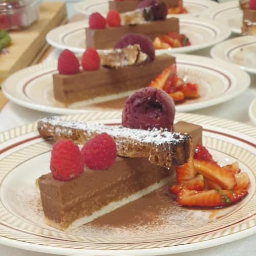 Élégant dessert au chocolat dressé avec framboises et fraises à La Maison de Philomène, Corme-Royal