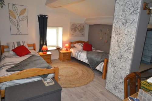 Chambre twin de La Maison de Philomène B&B à Corme-Royal avec lits en bois, oreillers rouges et vue sur le jardin