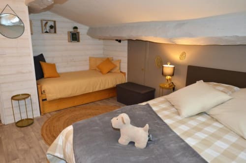 Chambre douillette à La Maison de Philomène B&B, Corme-Royal, avec lits jumeaux aux draps crème et petit lit de jour orange