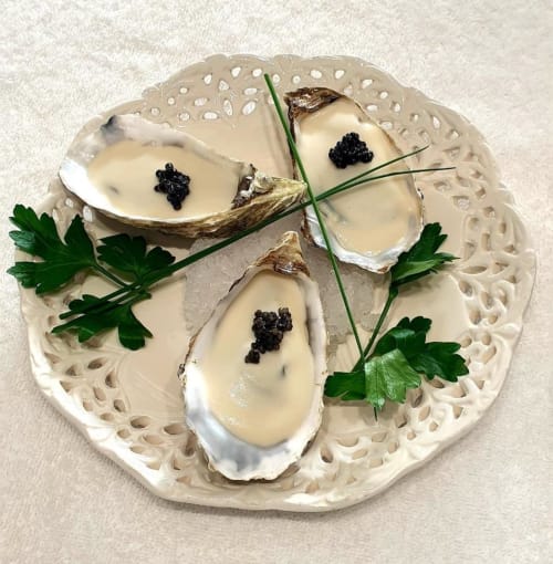 Quatre huîtres fraîches garnies de caviar sur assiette décorée à La Maison de Philomène, Corme-Royal France