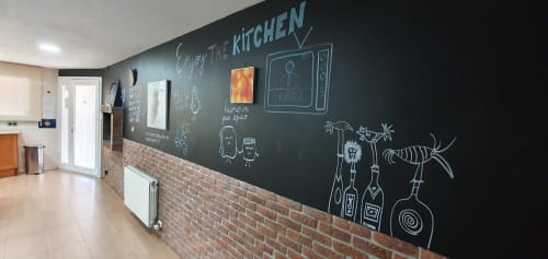 Pared de cocina con mural de pizarra con utensilios de cocina dibujados a mano y texto en Villa Castelló Salou, Salou
