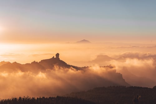 Cimas montañosas envueltas en niebla al amanecer cerca de Villa Castelló Salou, España con frondosos valles boscosos abajo