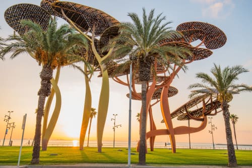Esculturas artísticas de palmeras al atardecer en el parque de la playa de Salou cerca de Villa Castelló