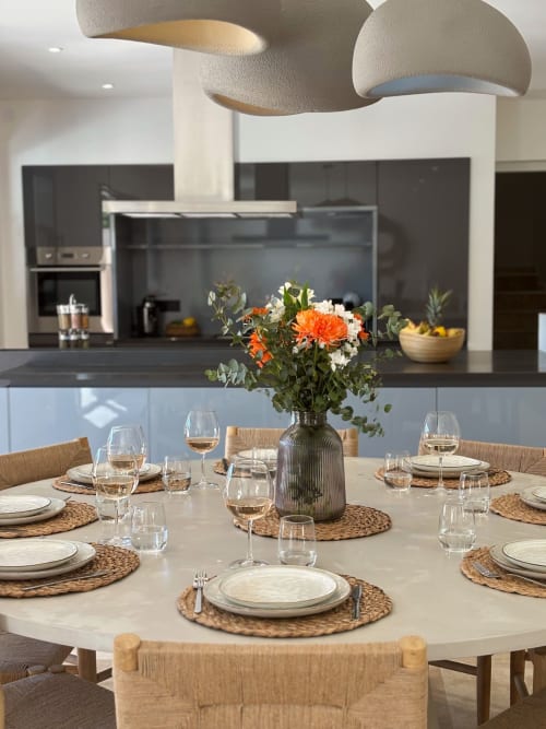 Elegante sala da pranzo nella Villa Grignan di La Maison D'ambrine con tavolo rotondo, mise en place e fiori freschi