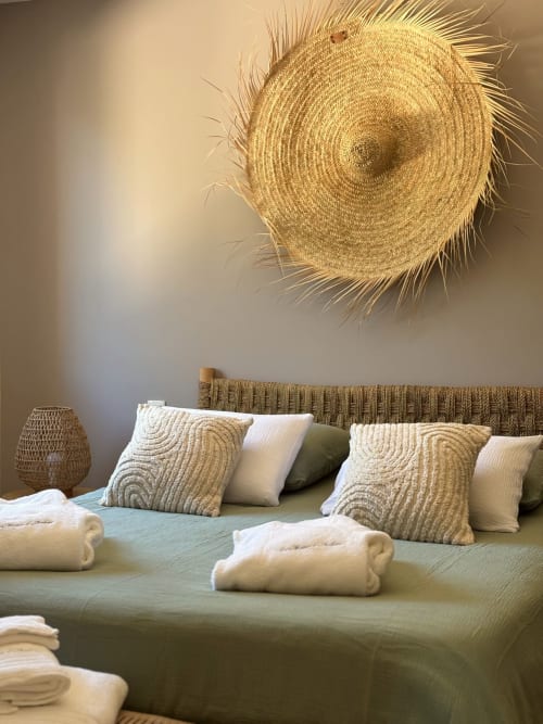 Camera da letto serena presso la villa La Maison D'ambrine a Chamaret con letto verde salvia, cuscini decorativi e arte tessuta parete