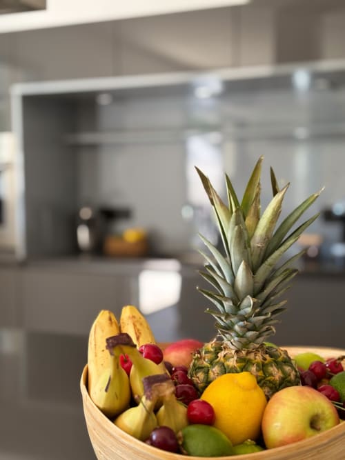 Ciotola di frutta fresca con ananas, banane e frutti di bosco nella cucina moderna di Villa Grignan, La Maison D'ambrine, Chamaret