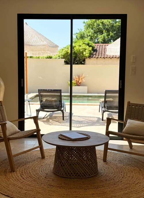 Moderna zona lounge con sedie in legno e tavolo rotondo affacciato sul patio di La Maison D'ambrine, Chamaret
