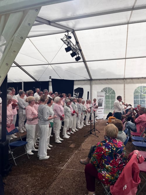 Groupe de chorale se produisant sous une tente lors de l'événement du Domaine de l'Ocrerie à Pourrain, France