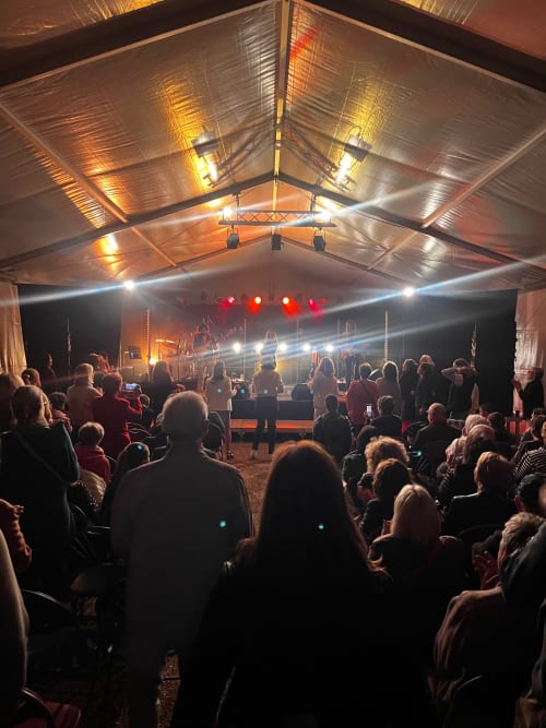 Concert en plein air sous chapiteau au Domaine de l'Ocrerie, Pourrain avec public et scène illuminée