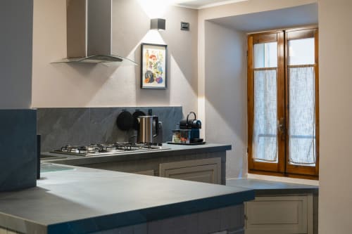 Cucina moderna nell'appartamento La Risorgente a Varenna by Foot, con elettrodomestici in acciaio inox e ripiani scuri