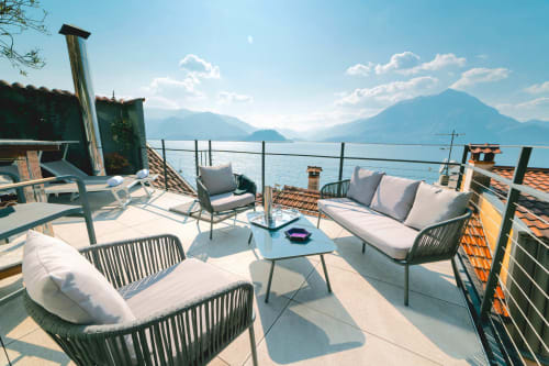 Terrazza soleggiata con vista panoramica sul Lago di Como a Varenna, arredata con comodi sedili e tavoli