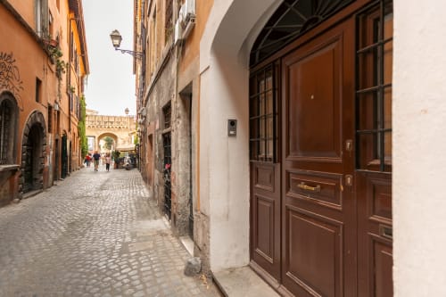 Charming cobblestone street in Rome's Trastevere with historic buildings and wooden doors