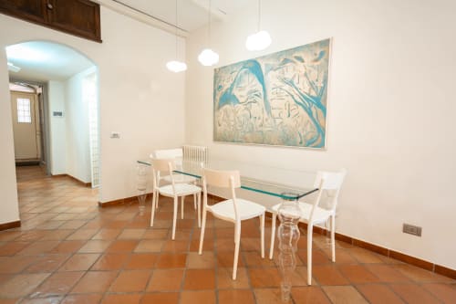 Modern dining area with white chairs and glass table in luxury Trastevere apartment, Roma