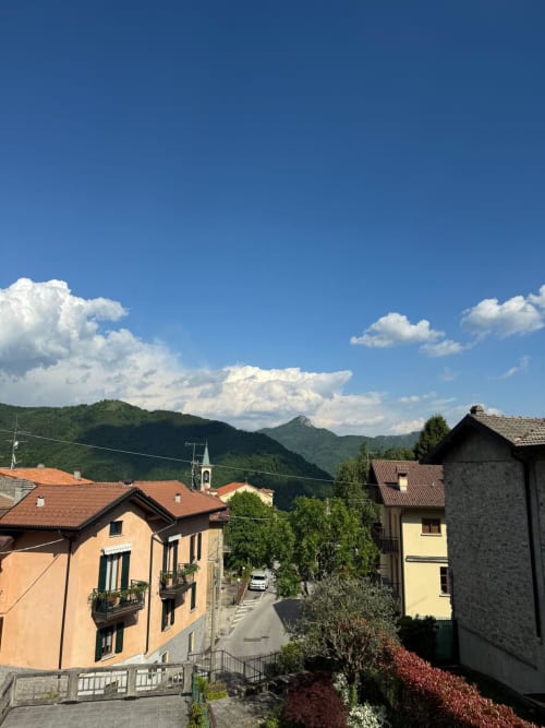 Colorful Alpine village buildings with mountain views in Sormano, Italy - THE V Collection apartment setting