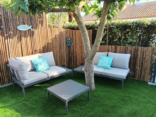 Coin détente accueillant à la villa Gîte des Gônes avec deux chaises longues confortables, coussins turquoise et arbre ombragé