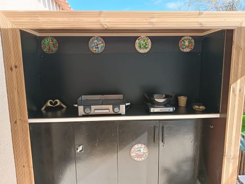 Cuisine extérieure du Gîte des Gônes avec grill, cuisinière et assiettes décoratives au-dessus des placards à Feyzin