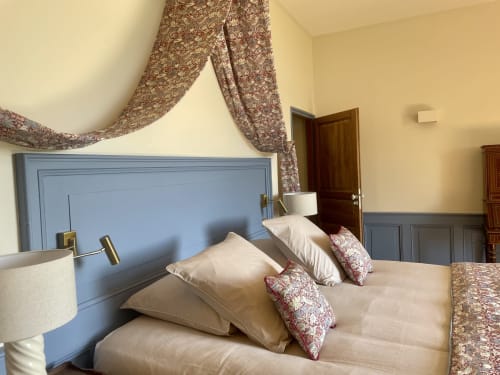 Chambre élégante au Château de Vaux Morvan avec tête de lit bleue, ciel de lit fleuri et literie crème à Étang sur Arroux