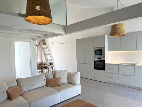 Vila moderna com plano aberto em Bordeira: sofá creme, luminárias de palha, cozinha equipada e vistas para o mar na Casa Beliche