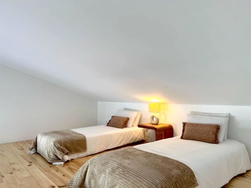 Aconchegante quarto no sótão da vila Casa Telheiro em Bordeira com camas de solteiro, iluminação acolhedora e piso de madeira