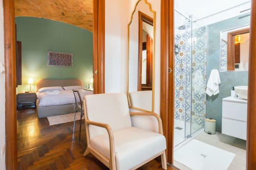 Elegante monolocale a Roma con camera da letto verde, bagno moderno, pavimenti in legno e arredi contemporanei