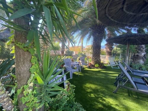 Petit coin détente côté piscine, Pelouse synthétique, arboré, fleuri, transats, parasol. Coin détente idéal pour profiter de ses vacances 
