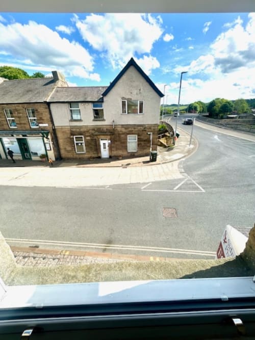 The Railway Hotel Haydon Bridge exterior in Haydon Bridge, Hexham, with stone buildings and river views nearby.