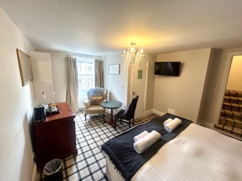 Superior King Room at The Railway Hotel Haydon Bridge featuring bed with towels, seating area, flat-screen TV, and chandelier