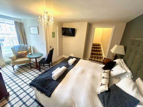 Superior King Room at The Railway Hotel Haydon Bridge featuring a king bed, TV, seating area, and checkered flooring