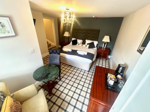 Superior King Room at The Railway Hotel Haydon Bridge featuring double bed, seating area, and checkered flooring