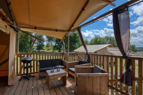 Terrasse de cottage glamping avec store rétractable, coin salon et vue sur les montagnes à Home Sweet Lodge Aquitaine