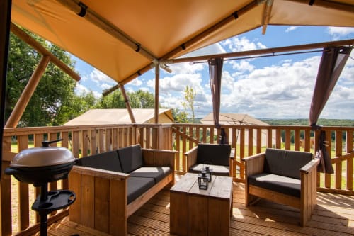 Glamping terras bij Home Sweet Lodge met houten meubilair, barbecue en uitzicht op het platteland van Aquitanië
