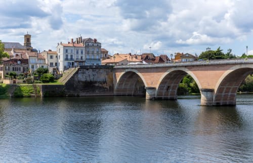 Pont en pierre historique enjambant la rivière avec charmant village français aux toits en terre cuite à Saint Germain et Mons