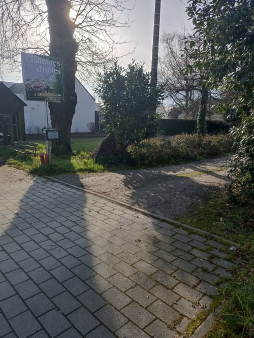 Entrée du gîte CafecouetBreizh à Guipry-Messac avec allée pavée, signalétique et haies de jardin