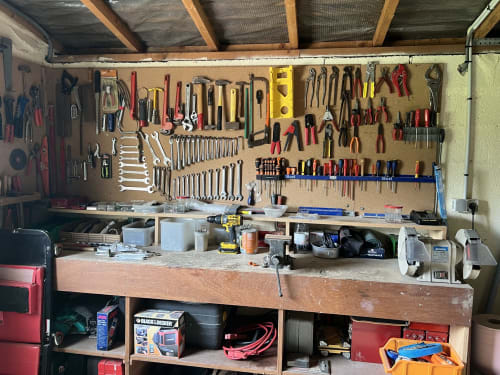 Atelier organisé avec mur à outils perforés et établi en bois à CafecouetBreizh