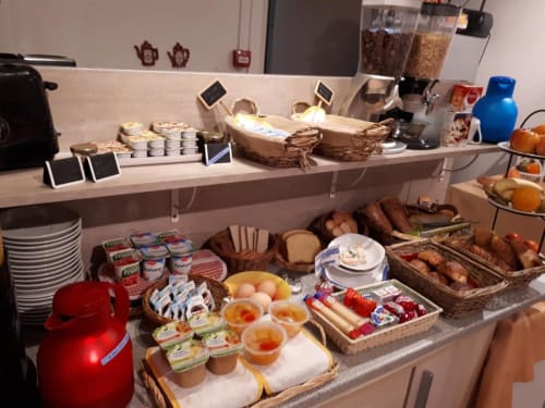 La Caravelle hotel breakfast buffet with pastries, bread, jams, and fresh fruit in Riom