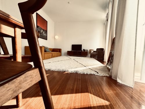 Spacious living room in Royal Prince Garden Apartments, Lisbon, with wooden furniture, cream rug, TV, and modern amenities