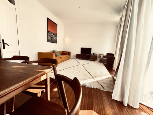 Spacious living room in luxurious 3-bedroom apartment at Royal Prince Garden Apartments, Lisbon, with dining table, sofa, TV,