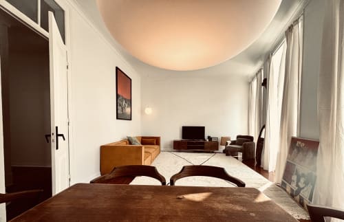 Spacious living room in Royal Prince Garden Apartments, Lisbon, with wooden furniture, sofa, TV, and large windows with