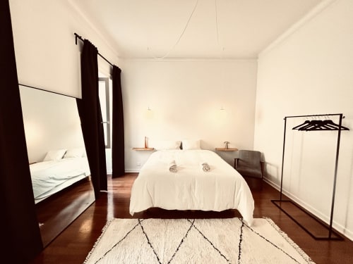 Spacious bedroom at Royal Prince Garden Apartments in Lisbon featuring canopy bed, parquet flooring, and modern amenities